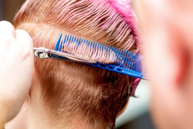 Kuaförün ellerinin arkası kadınların saçını kesiyor, yakın plan..