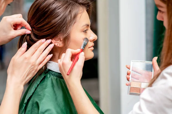 Młoda Kobieta Otrzymuje Makijaż Fryzurę Przez Profesjonalnego Charakteryzatora Fryzjera Salonie — Zdjęcie stockowe