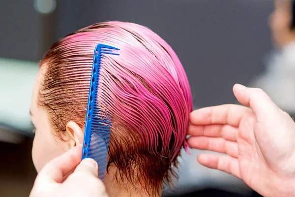 理发师的手正在梳理女人的粉红头发 非常近 — 图库照片