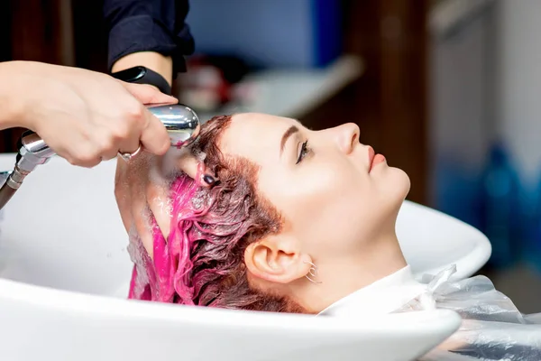 Fryzjerskie Ręce Myjące Różowe Farbowane Włosy Kobiety Zlewie Zbliżenie — Zdjęcie stockowe
