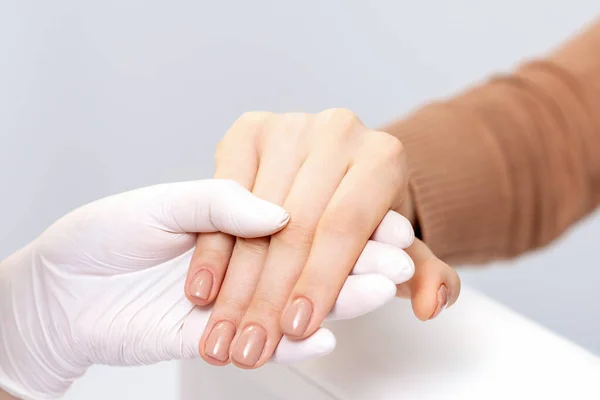 Manikiurzystka Trzyma Kobietę Rękę Beżowym Manikiurem — Zdjęcie stockowe