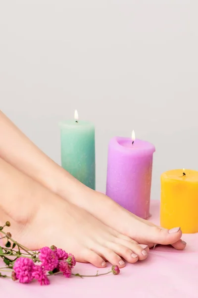 Beautiful Female Legs Barefoot Decorated Burning Candles Flowers White Background — Stock Photo, Image