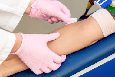 Hemşire elleri, tıp merkezine aşı vermeden önce kol derisini dezenfekte ediyor..