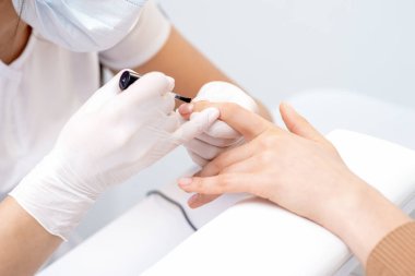 Manikür ustası elleri kadın tırnağına kadar pürüzsüz cilayı kapatıyor. Ellerin tırnaklarına dikkat et..