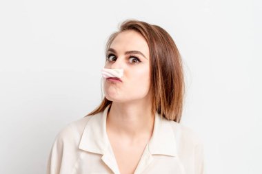 Beyaz arka planda şekerli şekerlemeyle bıyık yapan genç bir kadın. Defilasyon ve epilasyon kavramı.