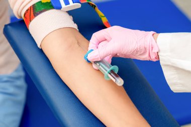 Hemşire el, koronavirüs aşısını tanıtıyor. Kadının koluna iğne batırıyor..