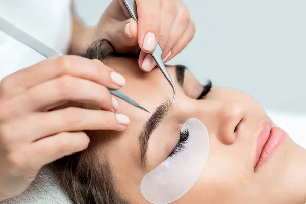 Kosmetolog Händer Håller Pincett Ovanför Ansiktet Ung Kvinna Ögonfransförlängning Förfarande — Stockfoto