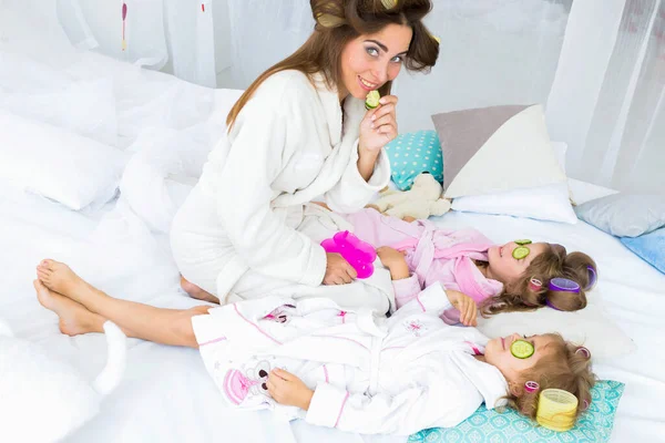 Madre Dos Hijas Están Poniendo Pepinos Los Ojos Con Rulos — Foto de Stock