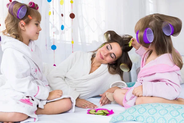 Madre Dos Hijas Están Poniendo Pepinos Los Ojos Con Rulos — Foto de Stock