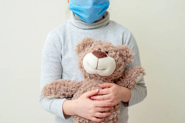 Niño Sostiene Osito Peluche Con Máscara Médica Protectora Sobre Fondo —  Fotos de Stock