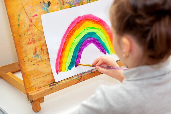 Dziecko Rysuje Tęczę Akwarelami Kartce Papieru Sztaludze Koncepcja Kreatywności — Zdjęcie stockowe