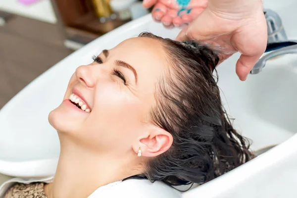 Kobieta Odbiera Mycie Włosów Umywalce Śmiejąc Się Salonie Fryzjerskim — Zdjęcie stockowe