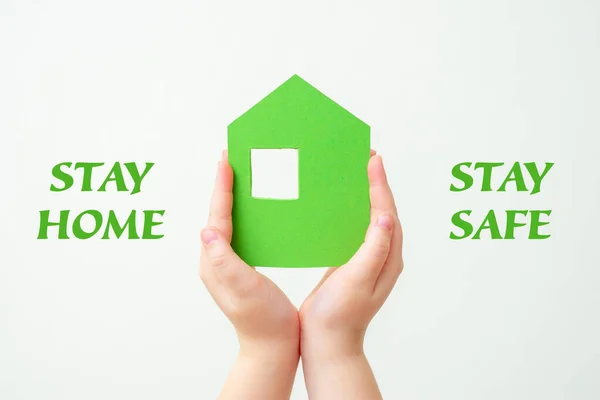 Ręce Dzieci Trzymające Zielony Papierowy Dom Słowami Stay Home Białym — Zdjęcie stockowe