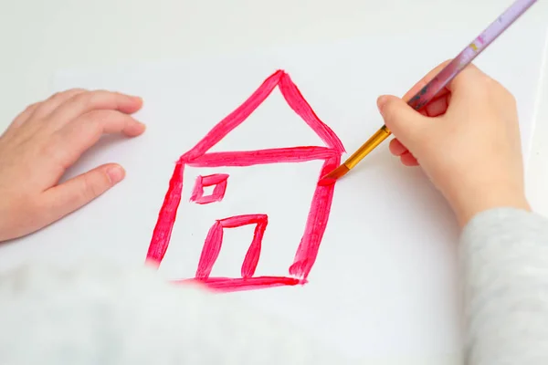 Kind Zeichnet Rotes Haus Mit Aquarellen Auf Weißem Blatt Papier — Stockfoto