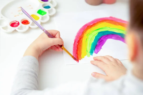 紙の上に水彩で子供の手で虹を描いた — ストック写真