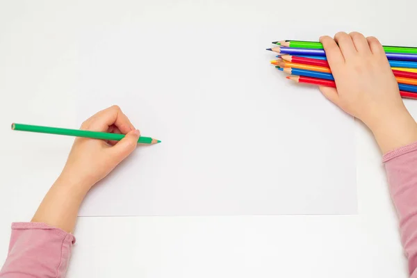 孩子们用绿色铅笔在白纸上画画的小手的顶部视图 手里拿着一束彩色铅笔 有选择的重点 — 图库照片