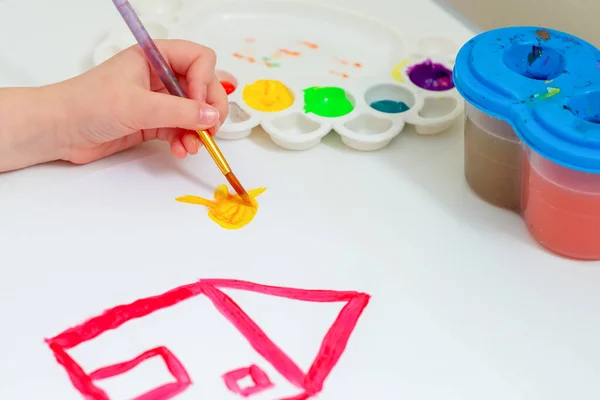 Kinderhände Zeichnen Gelbe Sonne Mit Rotem Haus Mit Aquarellen Auf — Stockfoto