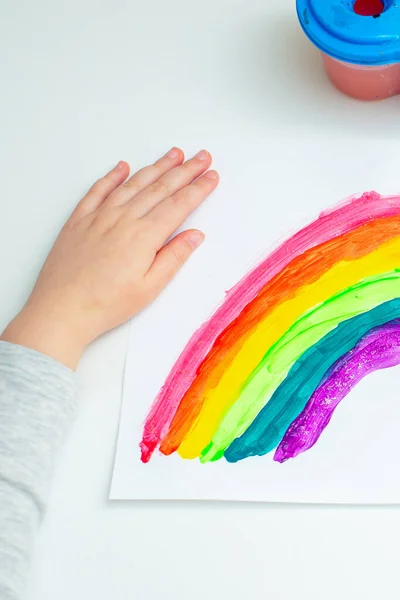 自宅でCovid 19隔離中に白い紙に虹を描いた子供の手のトップビュー 子供の創造性 — ストック写真
