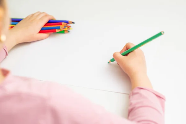小女孩拿着一束彩色铅笔 用绿色铅笔在白纸上画画 有选择的重点 — 图库照片