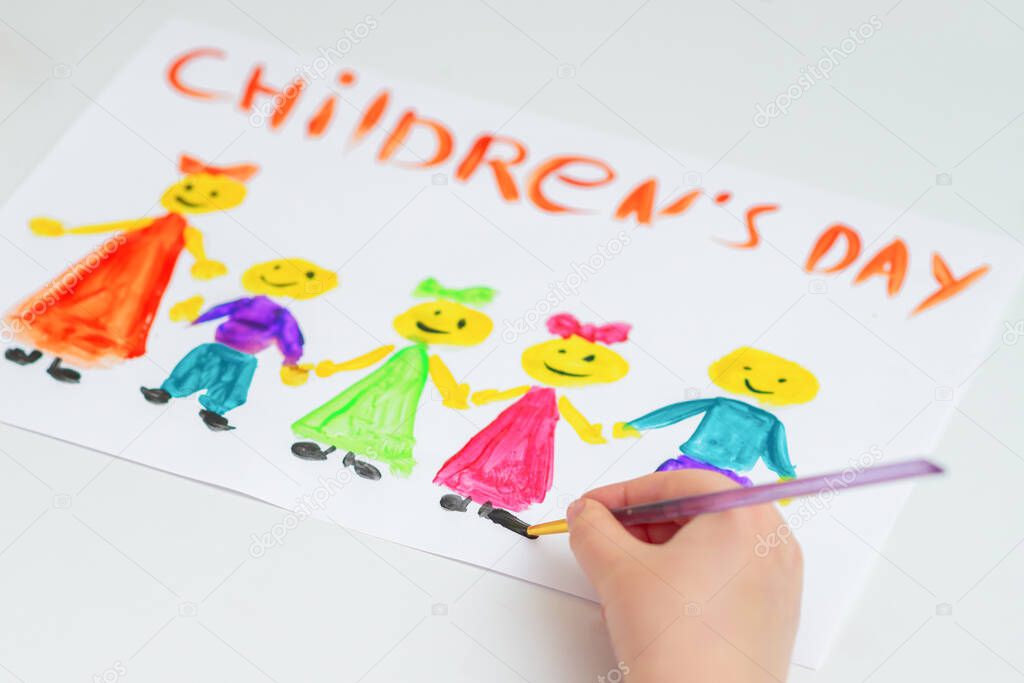 Hand of child drawing the different colorful children with words Children's Day on a white paper.