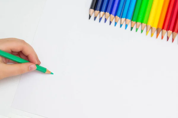 用一套彩色铅笔把孩子的手放在空白的白纸上的顶部视图 文本的复制空间 — 图库照片