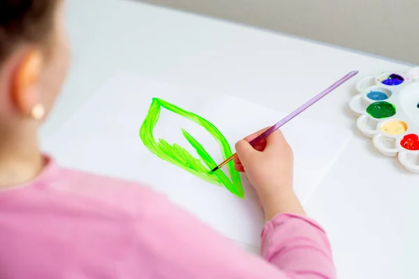 Kleines Mädchen Zeichnet Mit Pinsel Und Aquarell Grünes Blatt Auf — Stockfoto