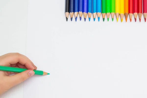 小宝宝用绿色铅笔在白纸上用彩色铅笔画图的顶部视图 孩子们绘画的概念 复制文本的空间 莫科普 — 图库照片