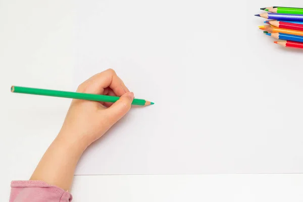 用绿色铅笔在空白的白纸上勾画出孩子左手的全景 复制文本的空间 莫科普 — 图库照片
