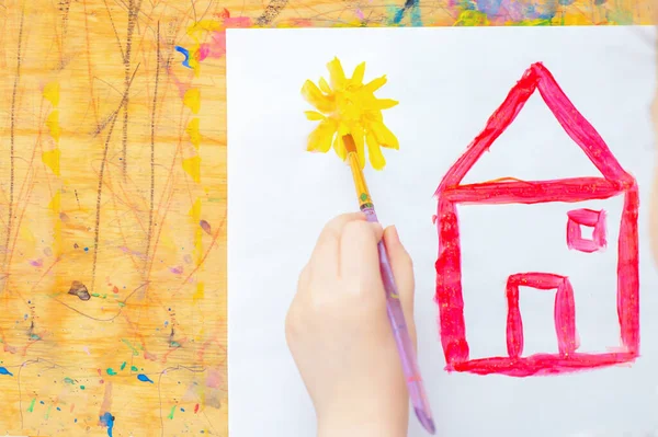 Kinderhand Zeichnet Sonne Mit Rotem Haus Auf Weißem Papier Auf — Stockfoto