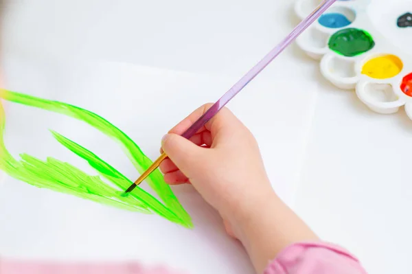 白い紙に水彩で緑の葉を描く子供の手の閉じる 地球の日のコンセプト — ストック写真