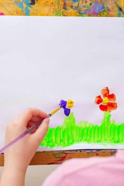 Kinderhand Zeichnet Blumen Auf Grünem Gras Mit Pinsel Von Aquarellen — Stockfoto