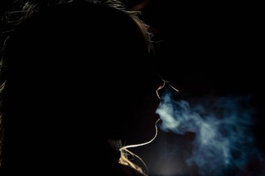 Geceleri şehirde sigara içen bir bayan.