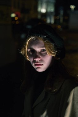 Şehirde gece yarısı sarı paltolu bir bayan