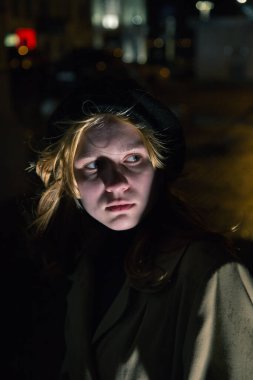 Şehirde gece yarısı sarı paltolu bir bayan