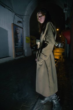 Şehirde gece yarısı sarı paltolu bir bayan