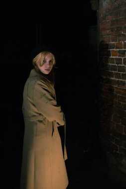 Şehirde gece yarısı sarı paltolu bir bayan