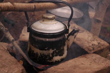 Ormandaki şöminede eski bir çaydanlık.