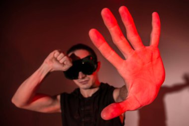 Kaynak gözlüklü bir adam kendini ışıktan korur.