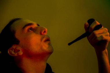 Yeşil arka planda pipo içen genç bir adam.