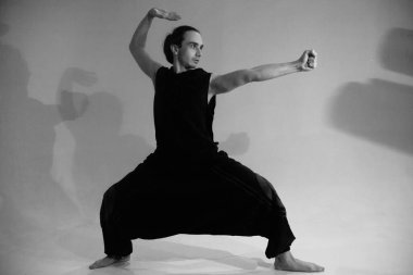 Savaşçı kılığındaki bir adam siyah beyaz poz verir. 