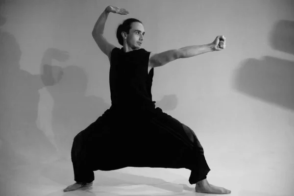 A man in a warrior pose  black and white