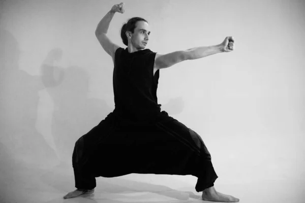 A man in a warrior pose  black and white