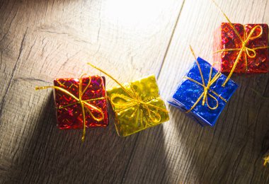 ahşap arka plan, üstten görünüm, yeni yıl ve Noel beş parlak renkli hediye kutuları.