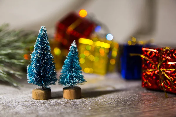 Дві маленькі зелені ялинки як символ нового року на дерев'яному тлі з фіолетовими зірками, мішура, вид зверху, є місце для тексту і підкладки — стокове фото