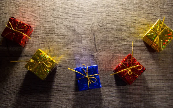 Ahşap arka plan, üstten görünüm, yeni yıl ve Noel beş parlak renkli hediye kutuları. — Stok fotoğraf