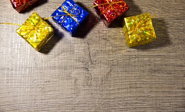 Vijf felgekleurde geschenkdozen op houten achtergrond, bovenaanzicht, Nieuwjaar en Kerstmis. — Stockfoto