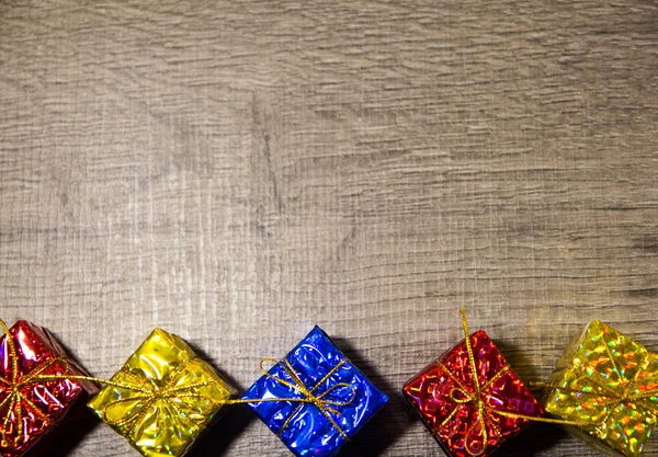 Cinq boîtes-cadeaux aux couleurs vives sur fond en bois, vue de dessus, nouvel an et Noël . — Photo
