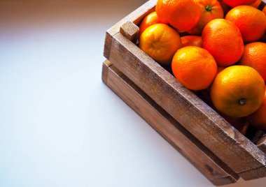 Ahşap kutusunda üzerinde beyaz izole yaprakları ile olgun lezzetli mandalina