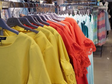 Giysiler tasarımcı giyim mağazasının rafında asılı.