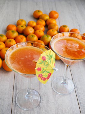 Kırsal ahşap arka planda cam içinde taze sıkılmış mandalina suyu.